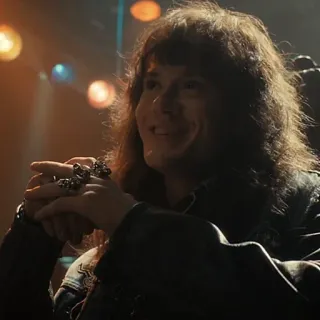 😉 Eddie Munson Stranger Things мужчина, длинные волосы, кожаная куртка, кольца, улыбается, телесериал telegram sticker