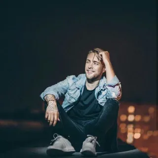 😏 f52d8939 Mann, sitzen, Jeansjacke, blonde Haare, lächelnd, Stadt, Nacht telegram sticker