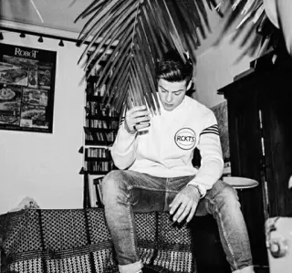 ▪️ 8c4c92f4 RCKTS mężczyzna, dżinsy, bluza, wewnątrz, siedzący, półka na książki, robot telegram sticker