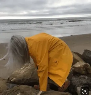 ✨ 3f5e544d plaża, ocean, osoba, skały, żółty płaszcz przeciwdeszczowy, siwe włosy telegram sticker